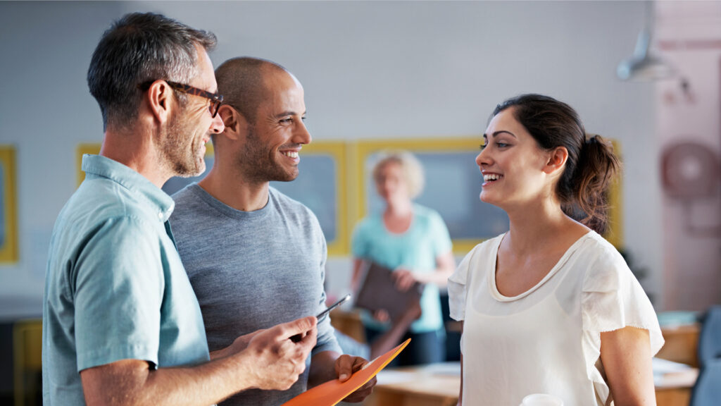 Lehrperson spricht mit Eltern im Schulzimmer